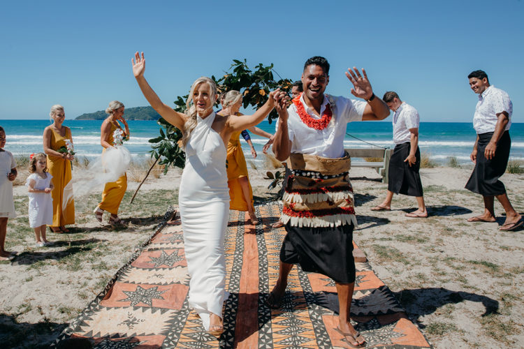 A stunning photo of a Bride and Groom who have just been announced as husband and wife. Their wedding ceremony was at Pauanui Beach, Coromandel in New Zealand. Their wedding photographer was Mala Photography from Auckland.