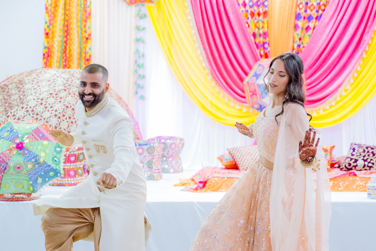 A photo of an Indian Bride and Groom dancing at their Sangeet. Photo taken by Mala Photography, an Auckland based photographer specialising in photographing Indian weddings.