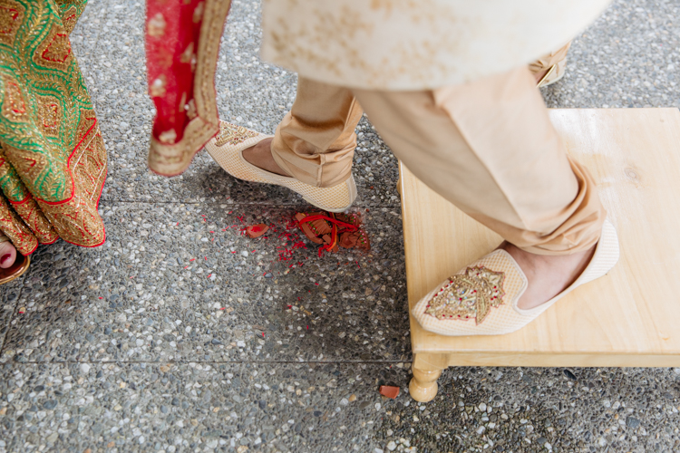 This is a photo taken by Mala Photography at a traditional Indian wedding. It's a photo of the Groom's entrance ceremony. It's conducted by a Hindu priest with the Groom and Bride's mother. 