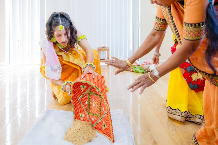 A photo of an Indian bride dressed in a bright yellow sari. This photo was taken on the day of her pre-wedding rituals, prayers and ceremonies. Photo taken by Mala Photography, an Auckland wedding photographer that specialises in Indian wedding photography.
